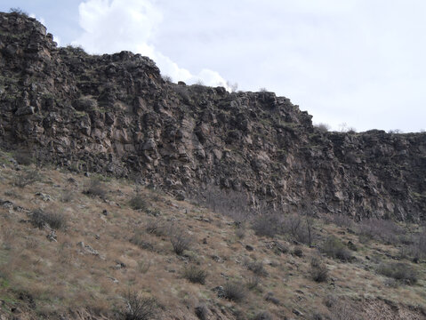 Basalt cliff with rocky slope. Armenia. Can be used as background for design projects. 