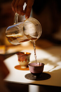 Traditional Tea Pouring from Glass Pitcher into Ceramic Cup