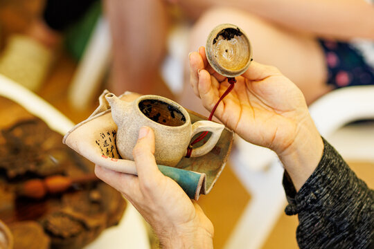 Man Hands Inspecting Dried Loose Leaves Inside Clay Teapot