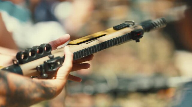 Tattooed hands loading a modern tactical shotgun