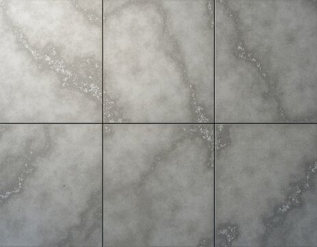Close view of six square grey stone tiles. Natural stone material shows rough texture and marble like veins. Clean even grout lines form grid.