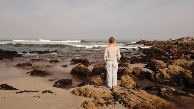 youn woman looking out at sea, Onrus Beach, Onrus, South Africa