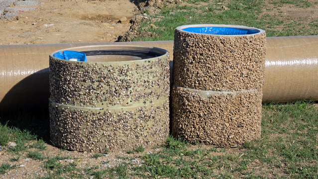 Polymer concrete manhole riser rings with aggregate texture on a construction site field