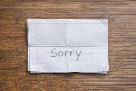 A piece of paper with the word 'sorry' written on it, used for expressing regret and apologizing