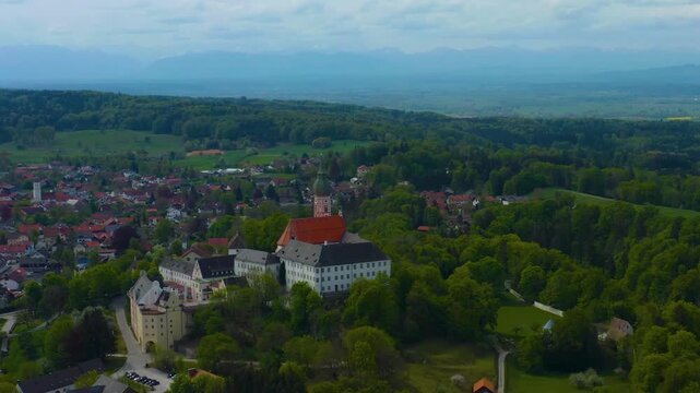 Aerial view above the city and monastery and brewery Andechs beside the Ammersee lake, on a cloudy noon in Spring in Germany
