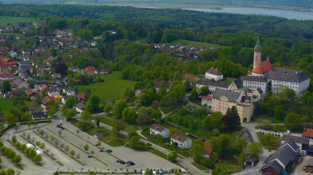Aerial view above the city and monastery and brewery Andechs beside the Ammersee lake, on a cloudy noon in Spring in Germany