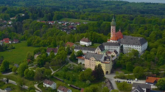 Aerial view above the city and monastery and brewery Andechs beside the Ammersee lake, on a cloudy noon in Spring in Germany