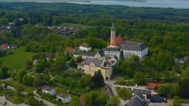 Aerial view above the city and monastery and brewery Andechs beside the Ammersee lake, on a cloudy noon in Spring in Germany