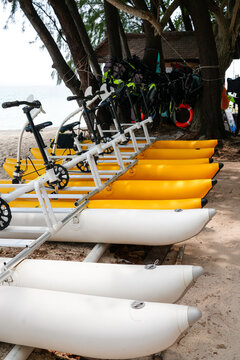 Row of water bikes parked on a tropical sandy beach at an island resort in Indonesia.