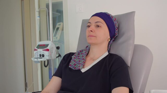 Woman receiving intravenous therapy in healthcare clinic while resting calmly in treatment chair, medical recovery environment expressing resilience, healing, wellness and patient care
