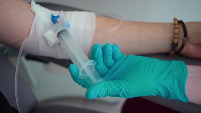 Healthcare professional administering chemotherapy through intravenous line in oncology clinic, cancer treatment procedure, medical care, precision and patient support