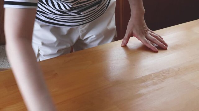 女性がテーブルを拭く様子