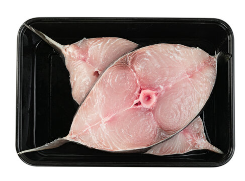 Fresh raw king mackerel fish steaks in a black plastic tray isolated. Top view of healthy seafood slices ready for cooking. Organic protein for keto diet and gourmet meal.