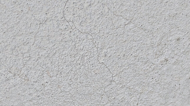 Weathered white concrete wall texture, cracked cement surface with grainy detail, industrial plaster background for architectural design