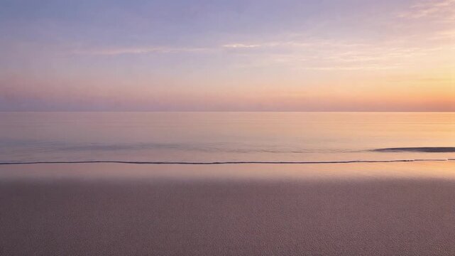 Calm ocean shoreline at sunset with pastel sky and gentle waves