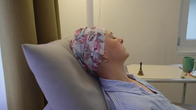 Close up profile of woman undergoing chemotherapy treatment, resting during cancer care session while demonstrating resilience, recovery and personal strength