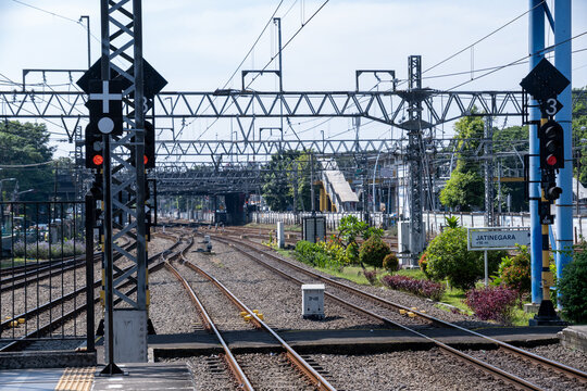 Multiple railway tracks and a railroad junction extending from a station platform with railway signals, showcasing urban rail infrastructure in Jakarta, Indonesia.