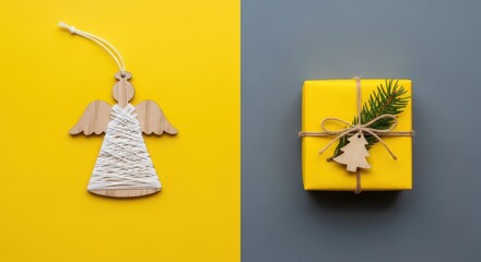 Obraz premium Christmas angel decoration and yellow gift box with fir branch on a split yellow and gray background
