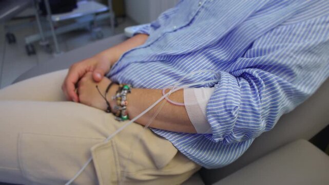 Close up of intravenous line connected to female cancer patient during chemotherapy treatment, healthcare procedure highlighting medical care, recovery and oncology support