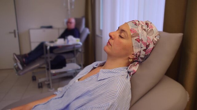 Female cancer patient resting during infusion therapy in healthcare clinic, reflecting resilience recovery and endurance during ongoing medical treatment