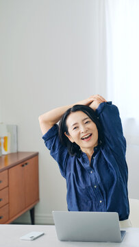 オフィスでストレッチするミドル女性