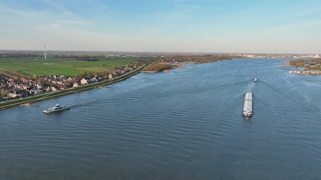 Commercial shipping on a major river near a Dutch town in Europe