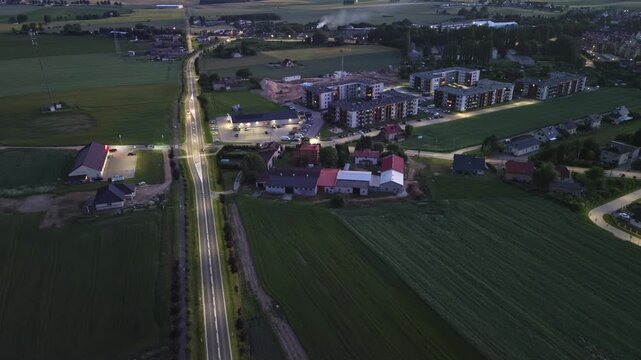Aerial Night Footage of Car Driving on Dark Rural Road with Apartments&ndash; 4K ProRes