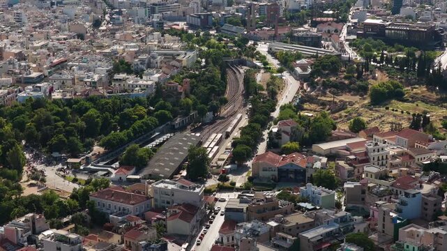 Athens cityscape featuring ancient ruins, Kerameikos metro station in Gazi neighborhood, urban landscape with railway tracks under a sunny sky in Greece