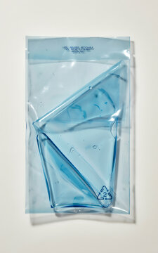 Blue gel pack inside transparent plastic packaging with recycling symbol isolated on white cooling cold container