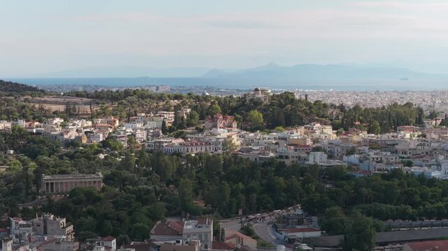 Athens cityscape flying above the Ancient Agora and Temple of Hephaestus revealing Plaka district, National Observatory, Saronic Gulf