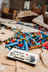 Vieux clavier et vieilles bobines de fil dans des cartons éventrés dans une usine abandonnée. Faillite industrie textile Lorraine et Vosges © david