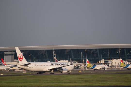 Jakarta, Indonesia - May 28, 2026: A Japan Airlines Boeing 767 taxiing at Soekarno-Hatta International Airport, with airport terminal buildings in the background.