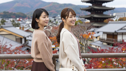 Fototapeta premium Enjoying Panoramic Autumn View from Traditional Japanese Tower, Cowboy shot, Copy space on the right
