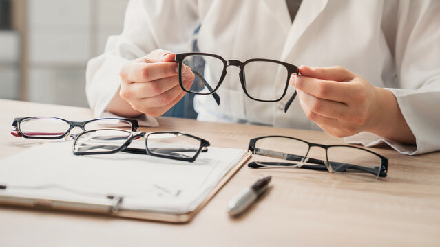 Ophthalmologist offers glasses to patient