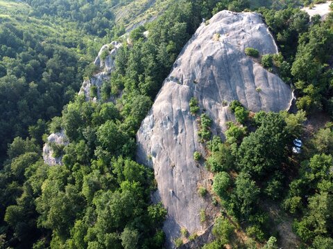 Aerial view of Sasso di Sant'Andrea, a prominent sandstone geological feature surrounded by dense forest. Zocca, Modena, Emilia-Romagna, Italy