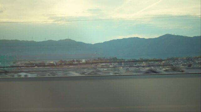 view of casual city and hills from moving fast express train window, Japan, Kobe, copy space