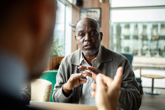 Businessman discussing project with colleague in cafe