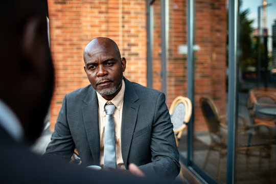 Businessman having serious conversation at outdoor cafe