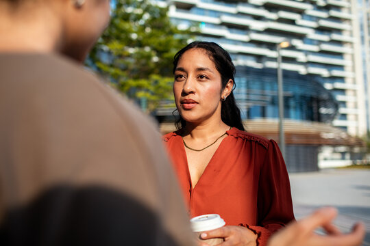 Woman listening during outdoor business conversation in city