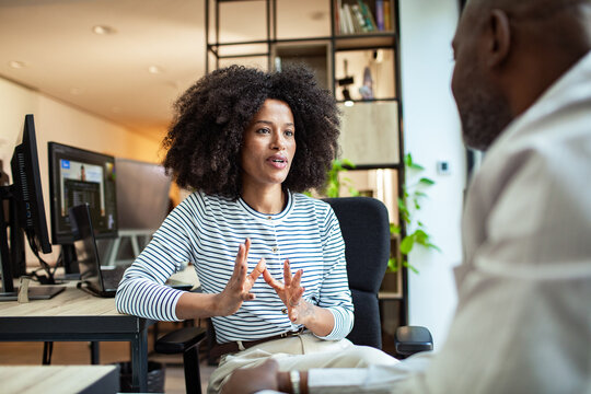 Businesswoman speaking with colleague in modern office
