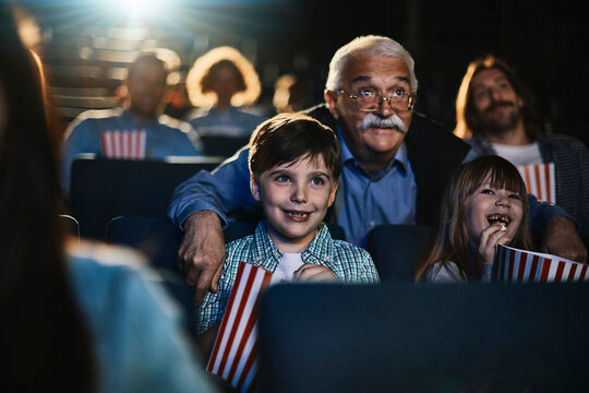 Grandfather and children watching a movie at the cinema
