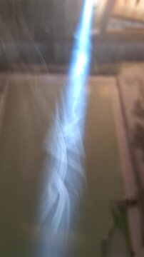 Bright sunbeam penetrating through a dark smoky indoor room creating a dramatic light ray effect in a rustic dim house interior