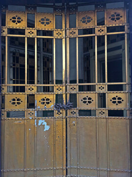 Ornate vintage golden metal gate with geometric patterns