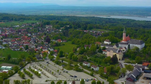 Aerial view above the city and monastery Andechs beside the Ammersee lake, on a cloudy noon in Spring in Germany