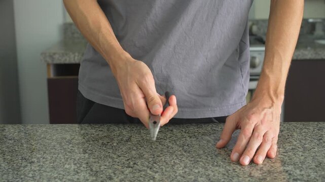 Close up man examining and clicking pliers with clear sound. Hands testing tool at table. Mechanical work, craftsmanship, repair process and satisfying ASMR concept.