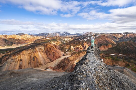 Hiker on the Laugavegur trekking trail, Laugavegur trekking trail, Dramatic volcanic landscape, Colourful erosion landscape with mountains, Lava field, Landmannalaugar, Fjallabak nature reserve, Su&eth;urland, Iceland