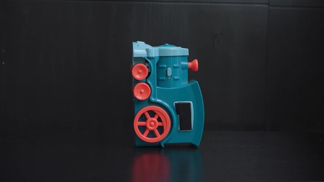 High-quality sound recording in uncompressed WAV format of a children's toy train standing on a table, with one wheel spinning and producing a simple mechanical toy sound for editing and audio library