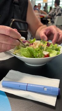 ozempic pen medical injection weight loss drug healthy food salad restaurant background, person eating lunch with diabetes medication, clinical treatment process, concept of healthcare and wellness