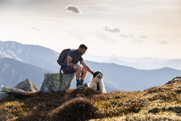 Obraz premium man with white dog trekking in the Low Tatras