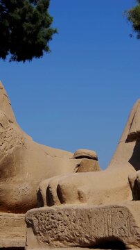 Karnak Temple in Luxor, Egypt. Ram-headed sphinx alley at Karnak Temple. Ancient stone statues of Amun god along sacred processional avenue.